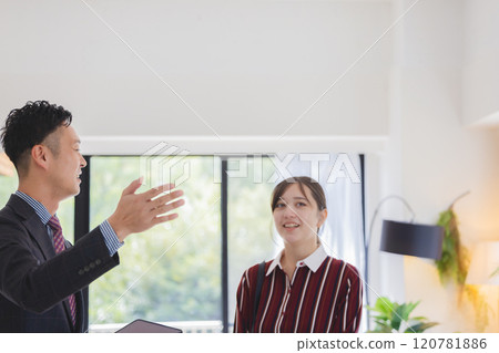 A woman and a salesman looking at a property 120781886