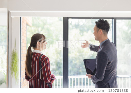 A woman and a salesman looking at a property 120781888