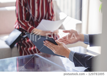A businessman holding a tablet and explaining 120781895