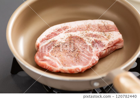 Cook pork shoulder steak in a frying pan 120782440