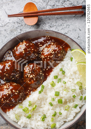 Sweet and spicy meatballs in honey sriracha sauce served with rice close-up in a bowl. Vertical top view Sweet and spicy meatballs in honey sriracha sauce served with rice close-up in a bowl. Vertical top view 120782665