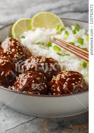Asian Honey Sriracha Meatballs with rice closeup on the bowl. Vertical Asian Honey Sriracha Meatballs with rice closeup on the bowl. Vertical 120782672