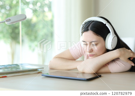 Serious asian woman watching media on tablet at home 120782979