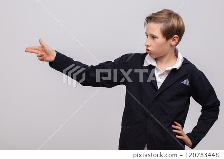 A schoolboy boy shows a gun gesture with his fingers. A schoolboy boy shows a gun gesture with his fingers. 120783448
