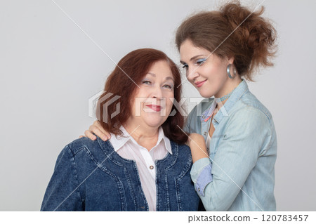 An elderly mother with an adult daughter. The mother-in-law and the young bride hug. An elderly mother with an adult daughter. The mother-in-law and the young bride hug. 120783457