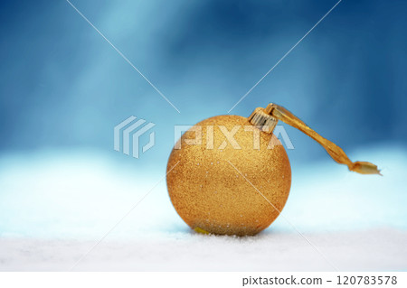 A Christmas card. A golden Christmas ball on a blue winter background. A Christmas card. A golden Christmas ball on a blue winter background. 120783578