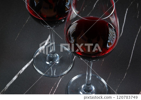 Image of two wine glasses filled with red wine making a toast Image of two wine glasses filled with red wine making a toast 120783749