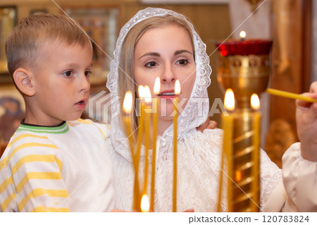 A woman in a headscarf with a child in an Orthodox church. 120783824