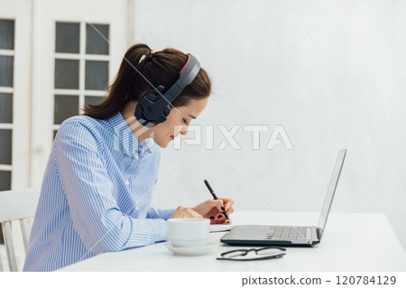 Business woman in headphones learning online 120784129
