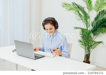 Business woman in headphones learning online laptop in office Business woman in headphones learning online laptop in office 120784131