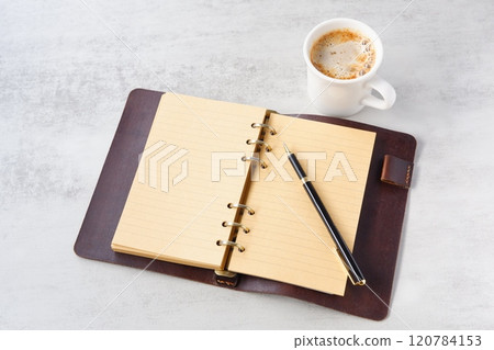 Image of a man working at his desk with a system organizer while drinking a cafe latte, a coffee with plenty of milk Image of a man working at his desk with a system organizer while drinking a cafe latte, a coffee with plenty of milk 120784153