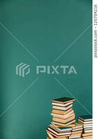 Stacks of books for reading and education in college library on green background Stacks of books for reading and education in college library on green background 120784216