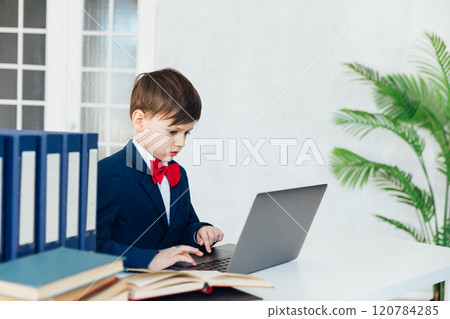 Little boy in business suit studying on laptop online 120784285