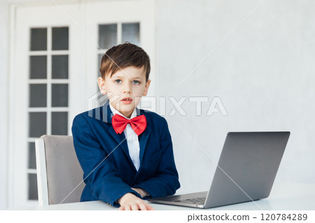 boy in business suit studying playing on laptop online 120784289