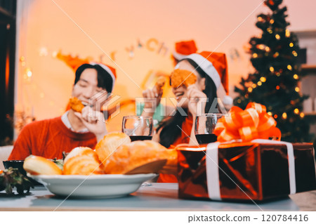 Group of young Asian man and women as friends having fun at a New Year's celebration, holding gift boxes standing by Christmas tree decoration, midnight countdown Party at home with holiday season. Group of young Asian man and women as friends having fun at a New Year's celebration, holding gift boxes standing by Christmas tree decoration, midnight countdown Party at home with holiday season. 120784416