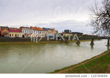 uzhhorod, ukraine - 18 feb, 2016: footbridge on the river uz in winter. season change. cloudy weather. urban landscape of the old city downtown. travel destination uzhhorod, ukraine - 18 feb, 2016: footbridge on the river uz in winter. season change. cloudy weather. urban landscape of the old city downtown. travel destination 120784689