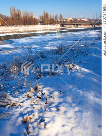 uzhhorod, ukraine - 03 jan, 2009: transportation bridge over the frozen river uz in winter. sunny weather. urban landscape of the old city downtown. white season in town 120784690