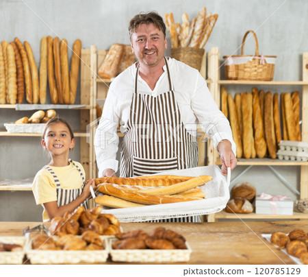 Baker dad and daughter are standing near product range in bakery kitchen. Baker dad and daughter are standing near product range in bakery kitchen. 120785129