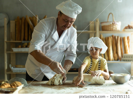 Bakers dad teaches his daughter niece to knead dough 120785151