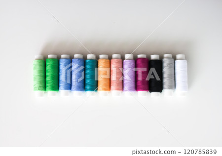 Many colorful sewing threads on light background. 120785839