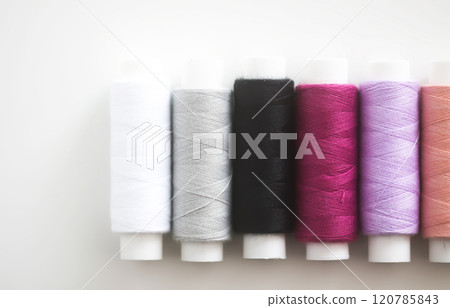 Many colorful sewing threads on light background. 120785843