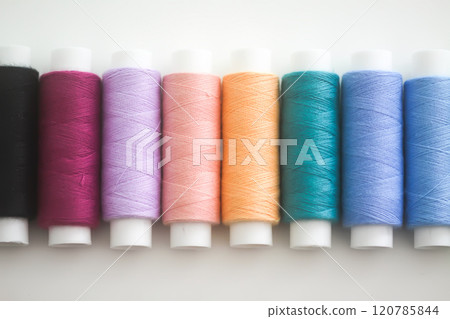 Many colorful sewing threads on light background. 120785844