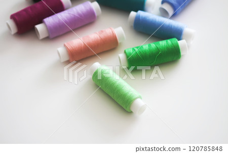 Many colorful sewing threads on light background. 120785848