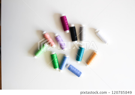 Many colorful sewing threads on light background. 120785849