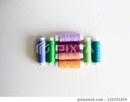 Many colorful sewing threads on light background. 120785854