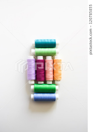 Many colorful sewing threads on light background. 120785855