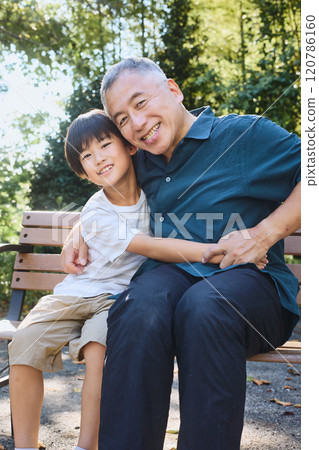 Grandson and grandfather standing close together Grandson and grandfather standing close together 120786160