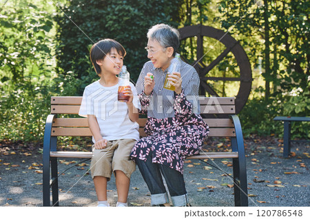 Grandmother and grandson enjoying a drink together 120786548