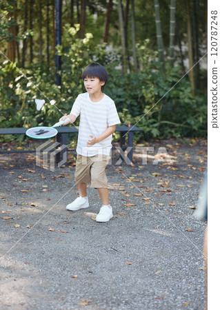A boy playing badminton 120787248