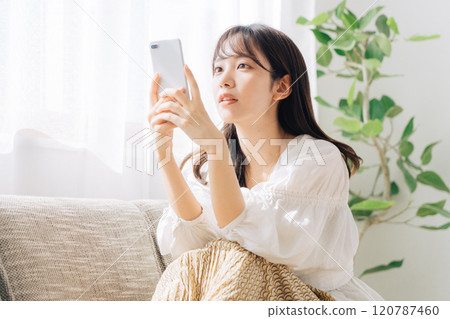 坐沙發和看智能手機的婦女 120787460