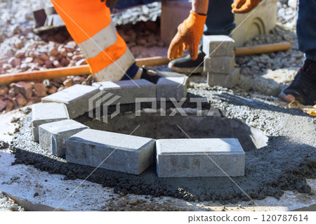 In fresh concrete is securing blocks making up uppermost edge of manhole for underground utilities well In fresh concrete is securing blocks making up uppermost edge of manhole for underground utilities well 120787614