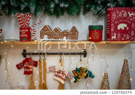 Christmas composition on the shelf in the kitchen interior. Beautiful decoration. Christmas trees, light and accessories. Merry Christmas and Happy Holidays 120788374