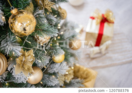 Christmas tree with gold toys. Festively decorated Christmas tree with garlands. Symbol of the new year in trend colors Christmas tree with gold toys. Festively decorated Christmas tree with garlands. Symbol of the new year in trend colors 120788376