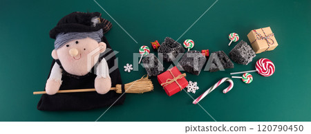 The Befana with sweet coal and candy on green background. Italian Epiphany day tradition The Befana with sweet coal and candy on green background. Italian Epiphany day tradition 120790450
