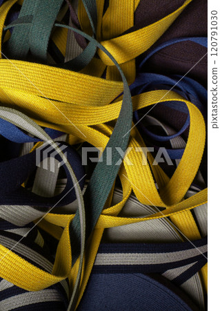 Tangled yellow and blue textile strips 120791030