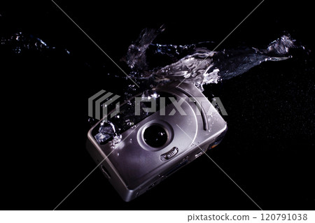 Drowning analog camera symbolizing technological evolution Drowning analog camera symbolizing technological evolution 120791038