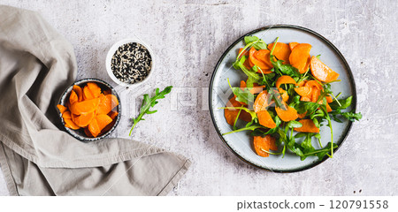 Vegetarian salad with sweet potato and arugula on a plate on the table top view web banner Vegetarian salad with sweet potato and arugula on a plate on the table top view web banner 120791558