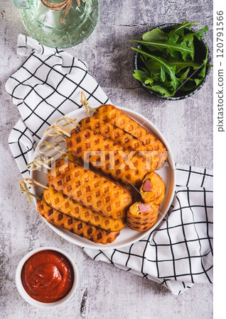 Grilled corn dogs with sausage on a plate and ketchup on the table top and vertical view Grilled corn dogs with sausage on a plate and ketchup on the table top and vertical view 120791566