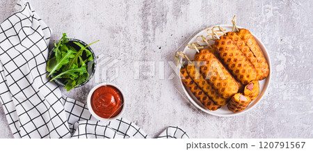 Grilled corn dogs with sausage on a plate and ketchup on the table top view web banner Grilled corn dogs with sausage on a plate and ketchup on the table top view web banner 120791567