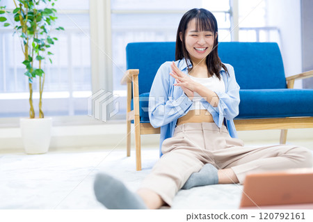 Young woman laughing while watching YouTube videos on a tablet Holiday Relaxing Watching Videos Young woman laughing while watching YouTube videos on a tablet Holiday Relaxing Watching Videos 120792161