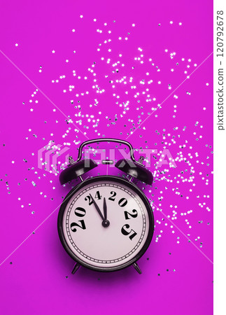 New Year 2025 background concept. 2024 changes to 2025 on an alarm clock on a colored background with festive glitter on New Year's Eve and Christmas. 120792678