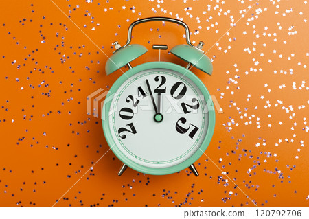 New Year 2025 background concept. 2024 changes to 2025 on an alarm clock on a colored background with festive glitter on New Year's Eve and Christmas. 120792706