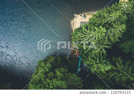 Synevir Lake with pine trees and tourists Synevir Lake with pine trees and tourists 120793135