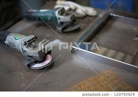 Finishing work on the welded part with a grinder Finishing work on the welded part with a grinder 120793929