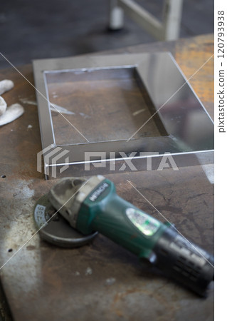 Finishing work on the welded part with a grinder Finishing work on the welded part with a grinder 120793938