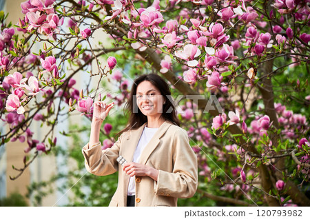 Woman allergic suffering from seasonal allergy at spring. Young happy woman holding pack of pills, posing in blossoming garden at springtime. Antihistamine medication concept 120793982